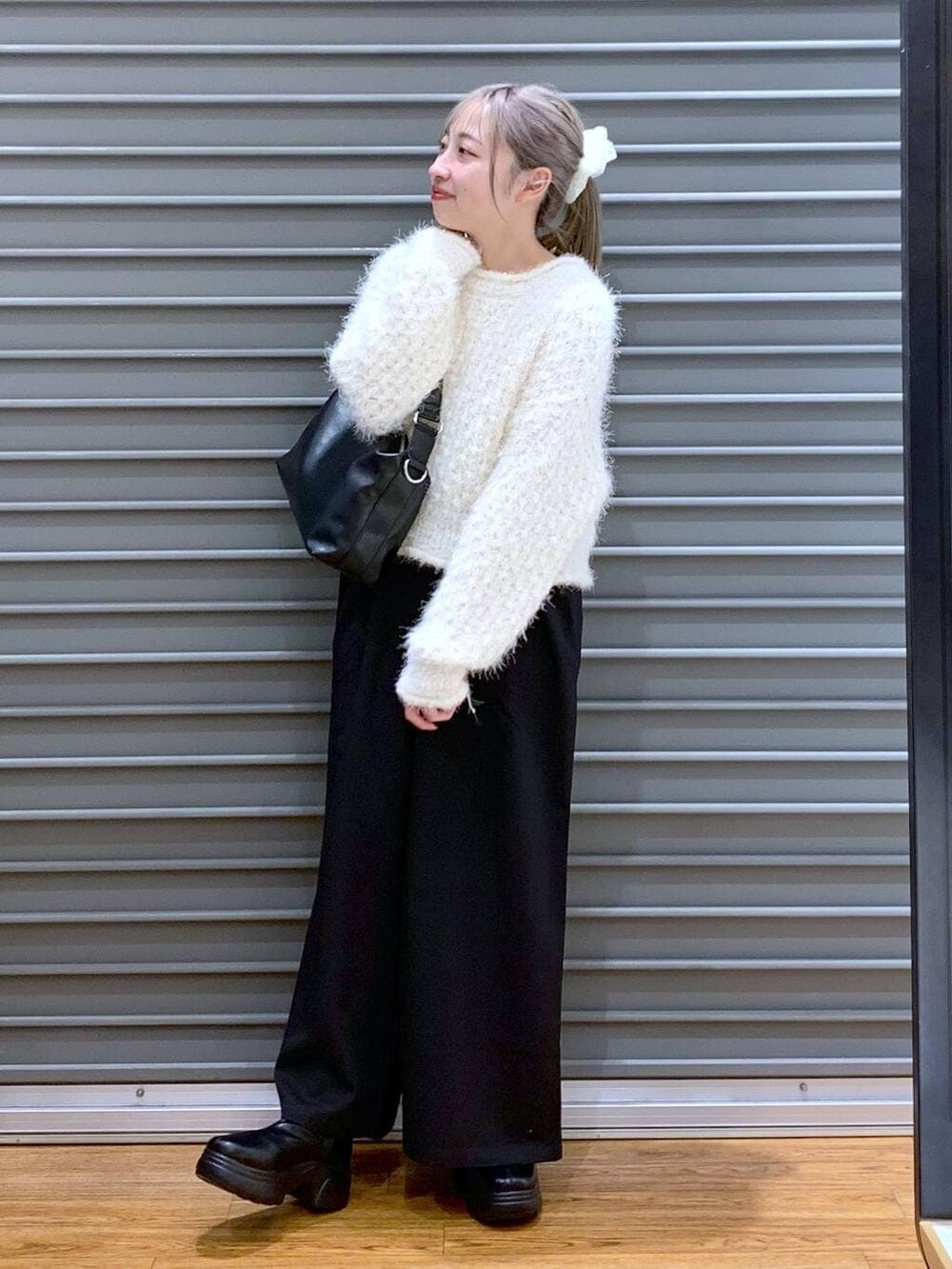 ブラック系のその他パンツ、ブラック系のショルダーバッグ、ブラック系のブーツを着用したレディースの冬コーディネートの4枚目の写真