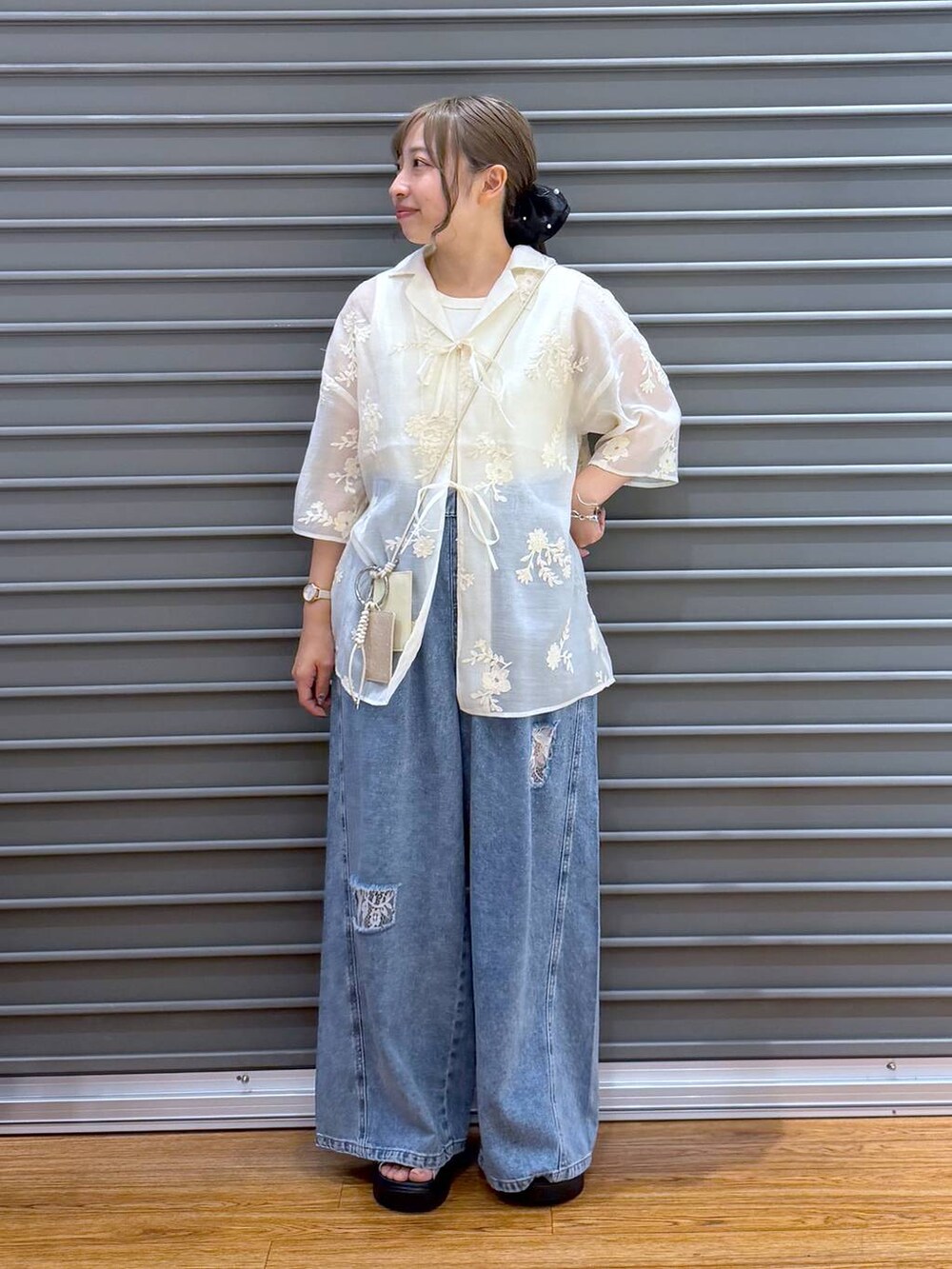 ホワイト系のサンダル、ホワイト系のタンクトップ、ブルー系のデニムパンツを着用したレディースの夏コーディネートの5枚目の写真