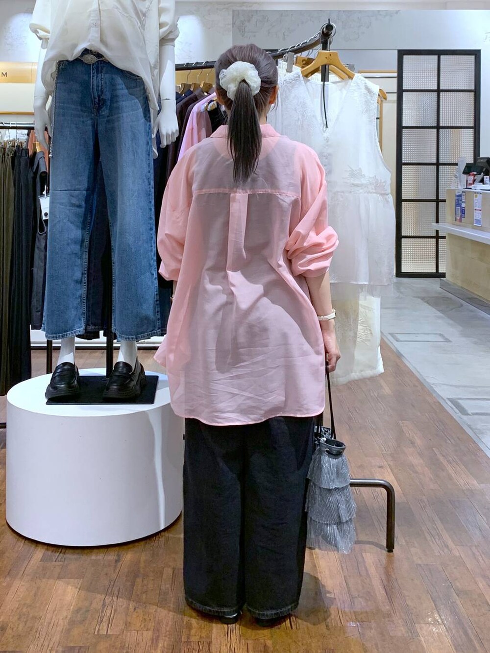 ピンク系のシャツ/ブラウス、ブラック系のデニムパンツ、シルバー系のショルダーバッグを着用したレディースの秋コーディネートの2枚目の写真