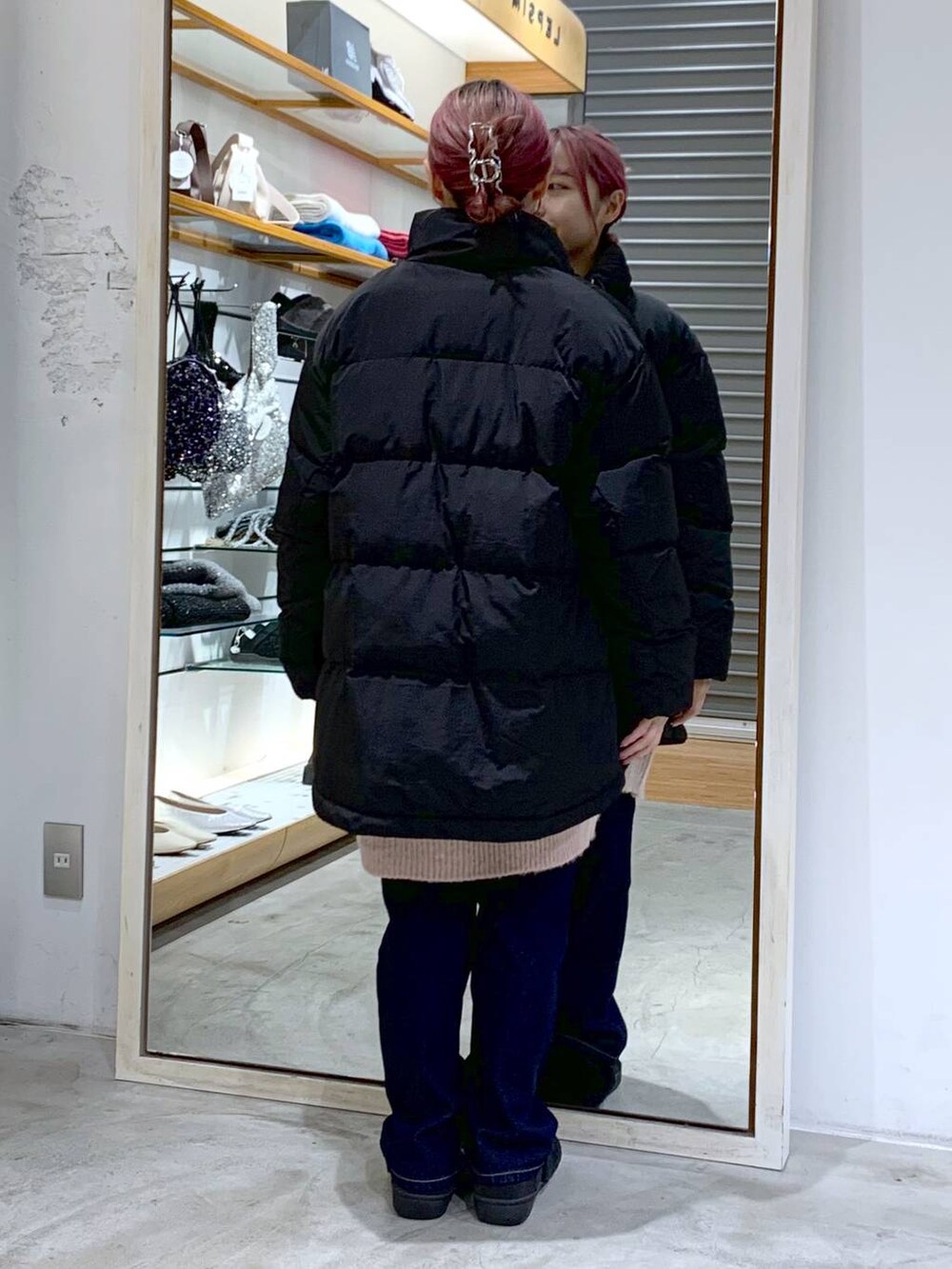 ブルー系のデニムパンツ、ブラック系のダウンジャケット/コート、ブラック系のその他シューズを着用したレディースの冬コーディネートの2枚目の写真