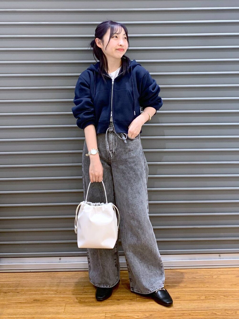 ブラック系のローファー、グレー系のデニムパンツ、ブルー系のパーカーを着用したレディースの春コーディネートの5枚目の写真