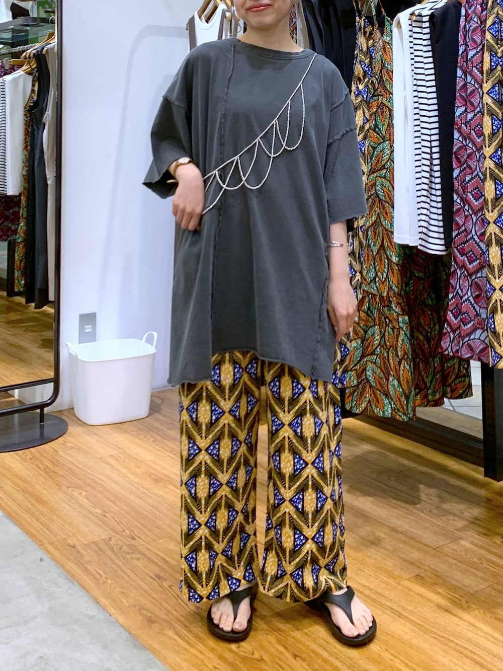 ブラック系のサンダル、グレー系のチュニック、オレンジ系のその他パンツを着用したレディースの夏コーディネートの4枚目の写真