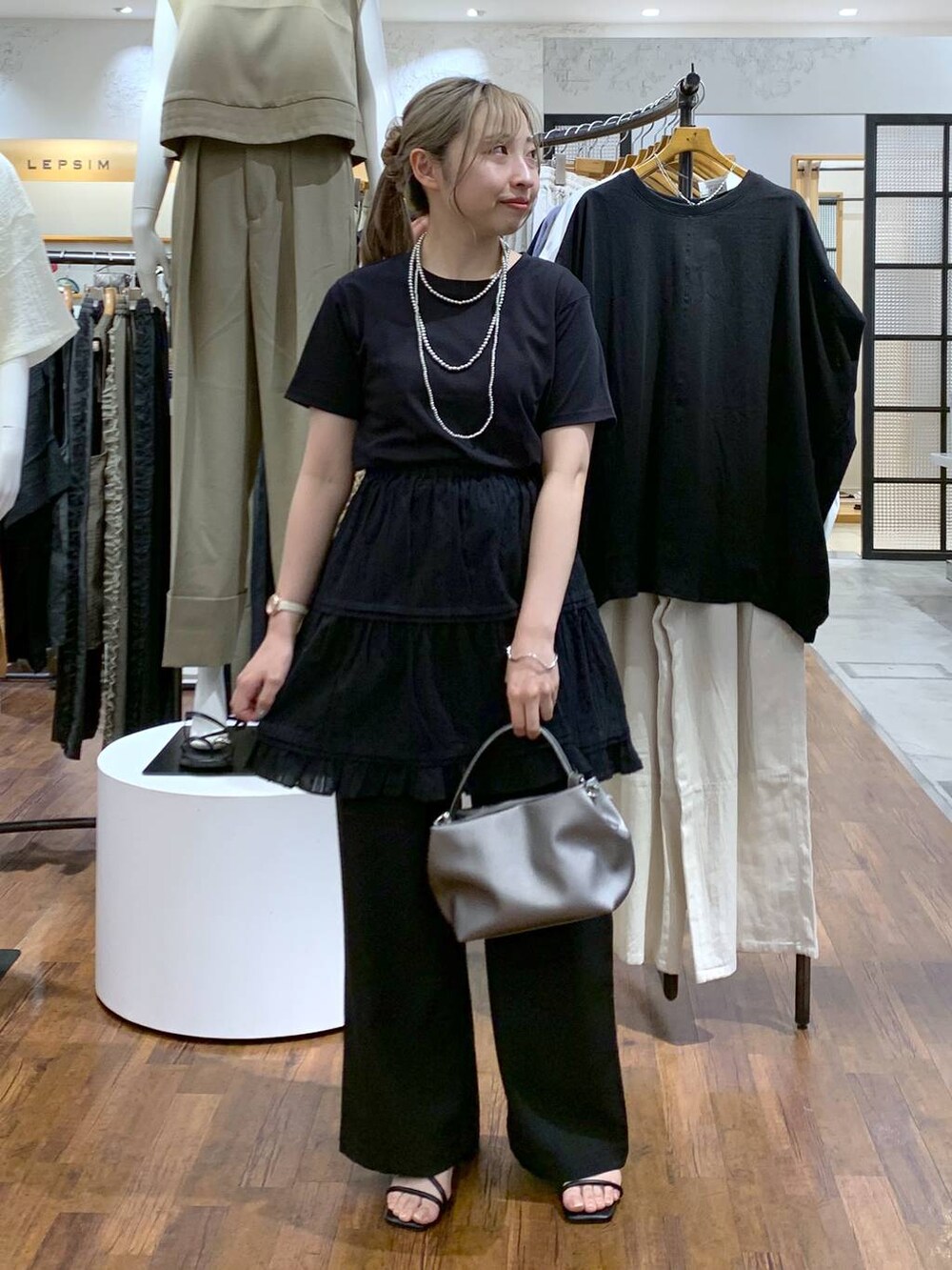 ブラック系のTシャツ/カットソー、ブラック系のサンダル、その他のショルダーバッグを着用したレディースの夏コーディネートの4枚目の写真