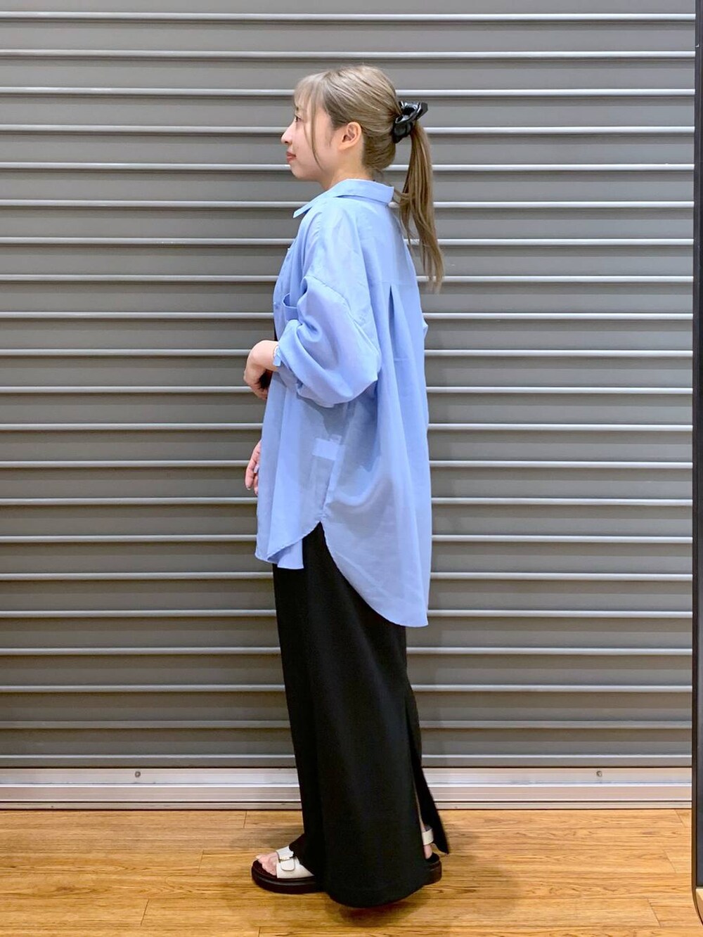 ホワイト系のサンダル、ブラック系のショルダーバッグ、ブルー系のシャツ/ブラウスを着用したレディースの夏コーディネートの3枚目の写真