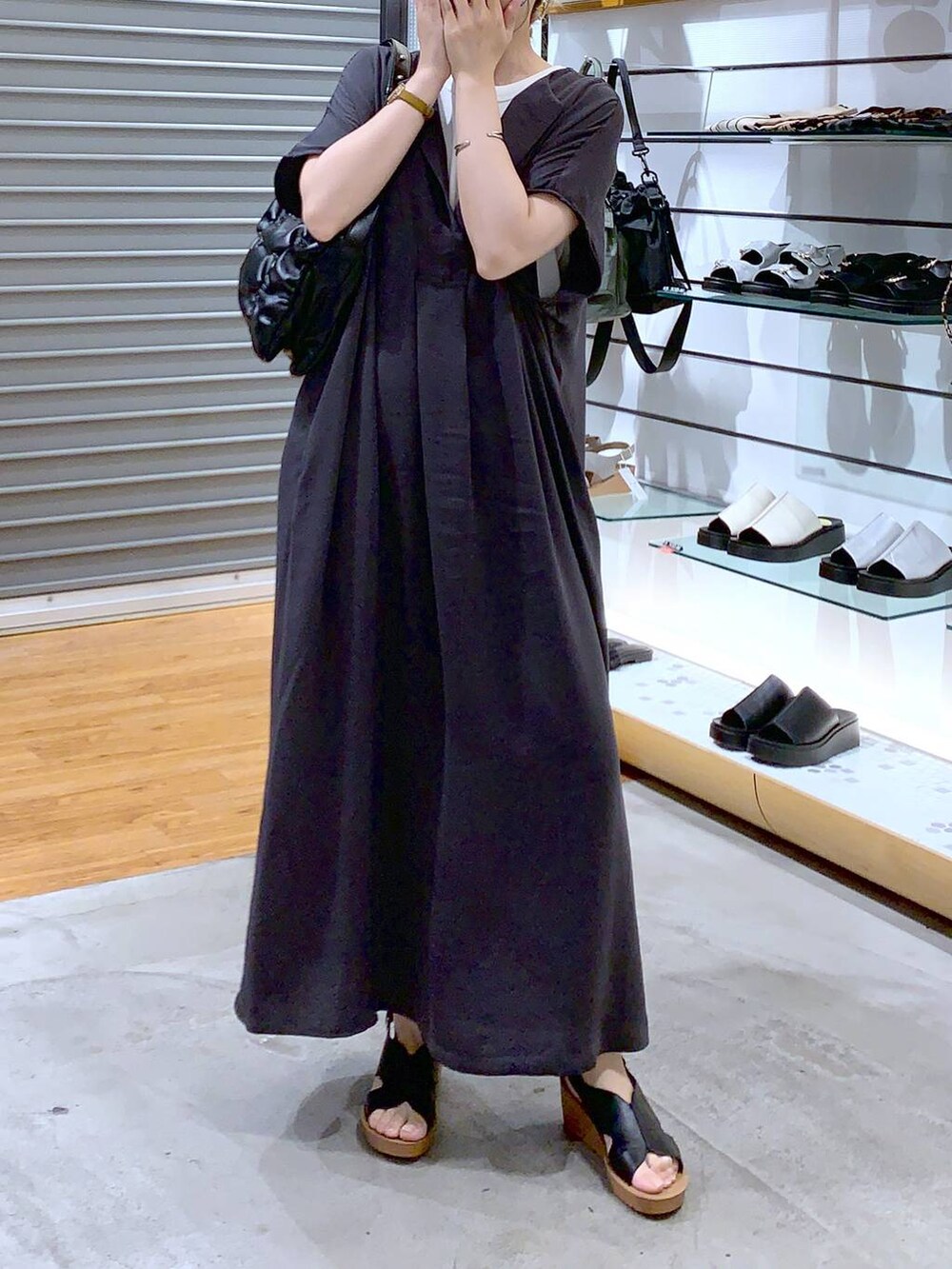 ブラック系のショルダーバッグ、グレー系のワンピース、ブラック系のサンダルを着用したレディースの夏コーディネートの6枚目の写真