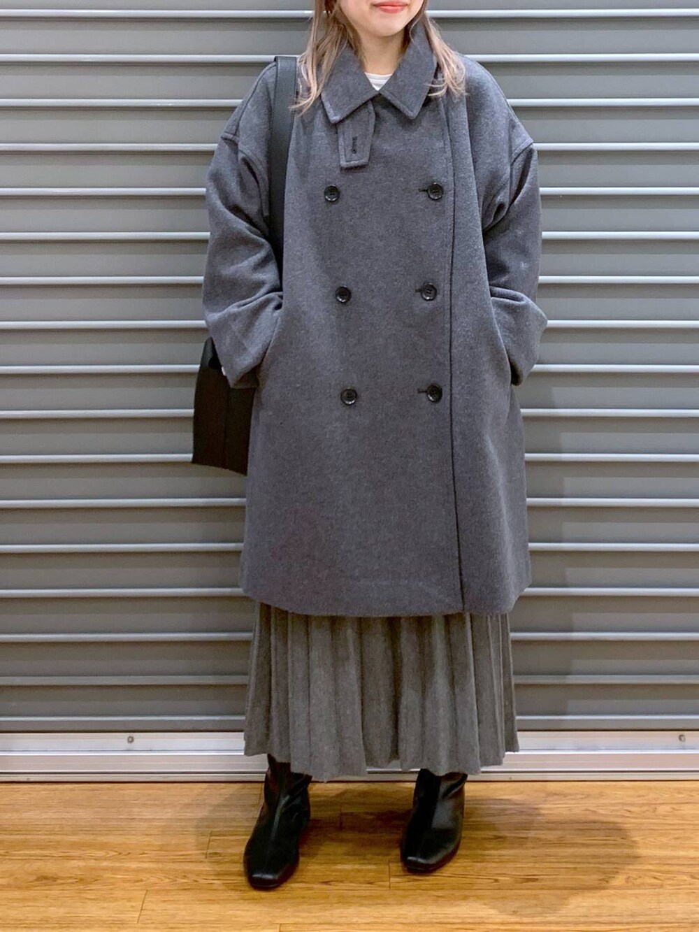 グレー系のその他アウター、ブラック系のブーツ、グレー系のワンピースを着用したレディースの冬コーディネートの6枚目の写真