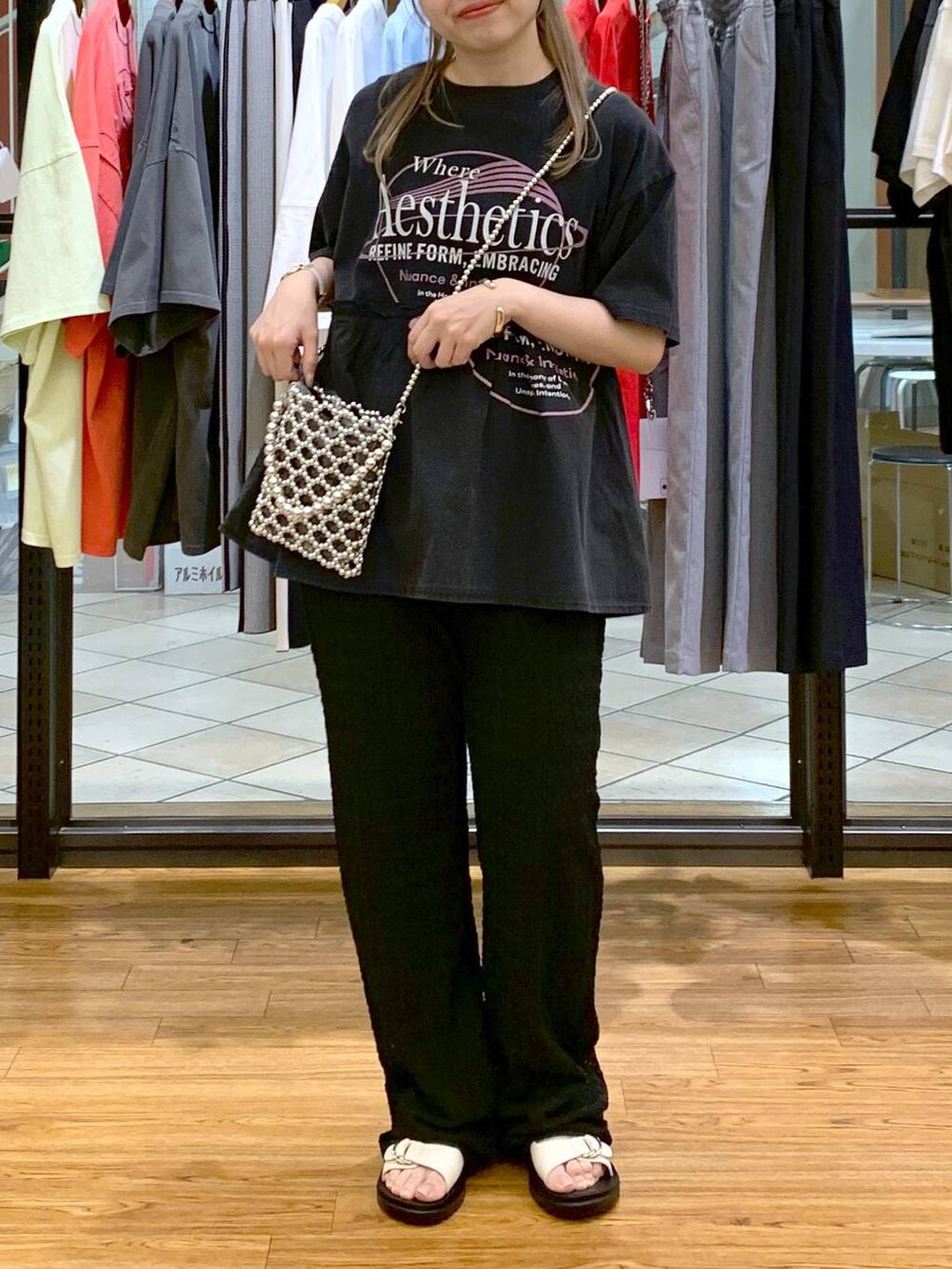 ホワイト系のサンダル、シルバー系のショルダーバッグ、ブラック系のその他パンツを着用したレディースの春コーディネートの6枚目の写真
