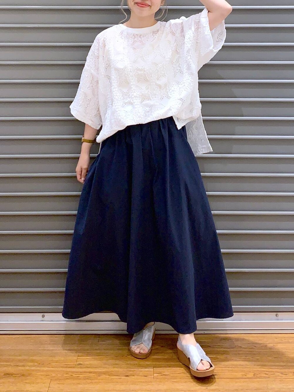 ブルー系のスカート、シルバー系のサンダル、ホワイト系のかごバッグを着用したレディースの夏コーディネートの3枚目の写真