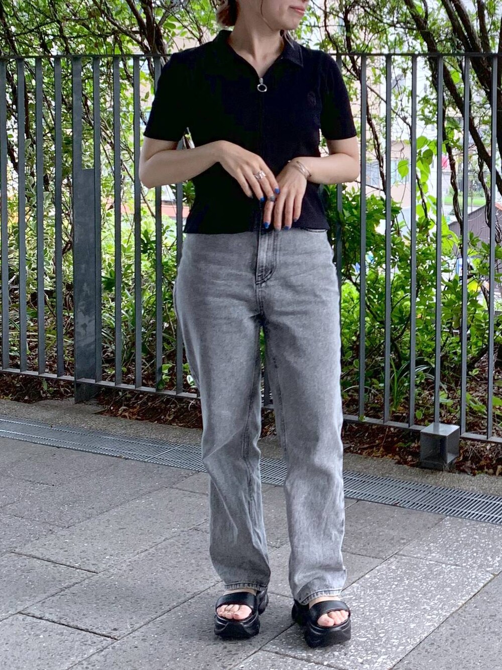 ブラック系のショルダーバッグ、ブラック系のサンダル、グレー系のデニムパンツを着用したレディースの夏コーディネートの3枚目の写真