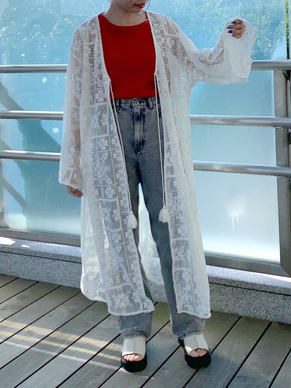 ホワイト系のワンピース、ホワイト系のサンダル、オレンジ系のタンクトップを着用したレディースの夏コーディネートの3枚目の写真