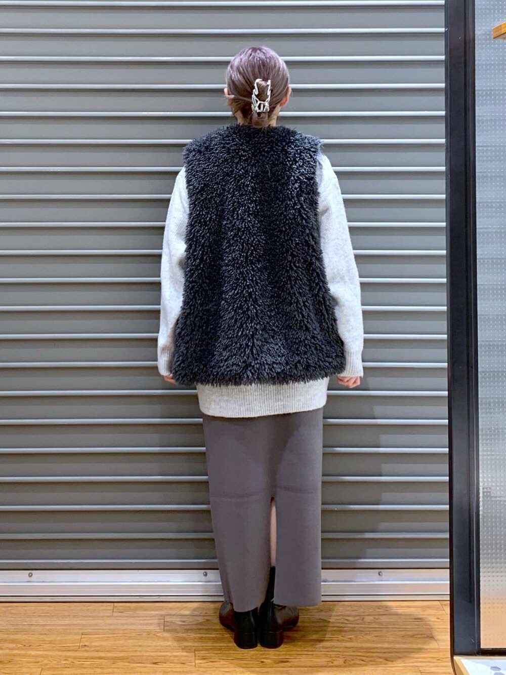 ホワイト系のショルダーバッグ、グレー系のスカート、ブラック系のブーツを着用したレディースの冬コーディネートの2枚目の写真