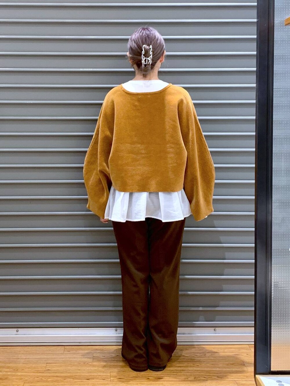 ブラック系のブーツ、ホワイト系のTシャツ/カットソー、ホワイト系のショルダーバッグを着用したレディースの冬コーディネートの2枚目の写真