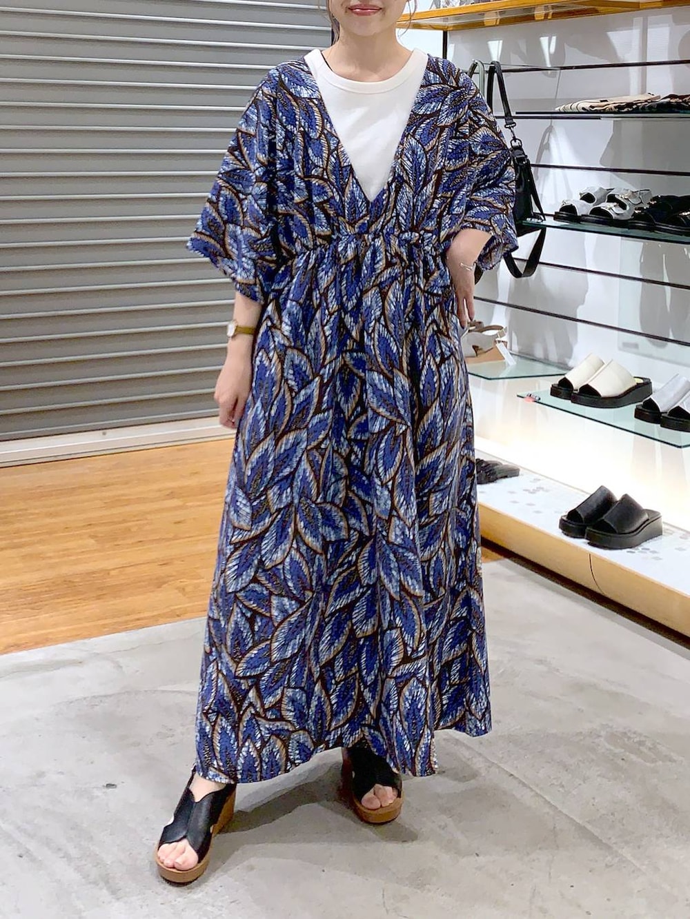 ブラック系のショルダーバッグ、ブラック系のサンダル、ホワイト系のタンクトップを着用したレディースの夏コーディネートの3枚目の写真