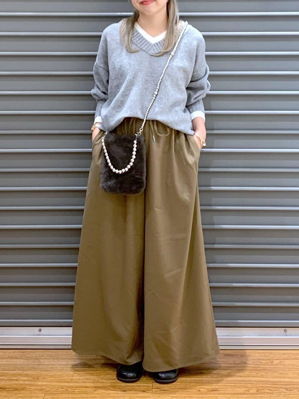 ブラウン系のその他パンツ、グレー系のニット/セーター、ブラック系のブーツを着用したレディースの冬コーディネートの5枚目の写真