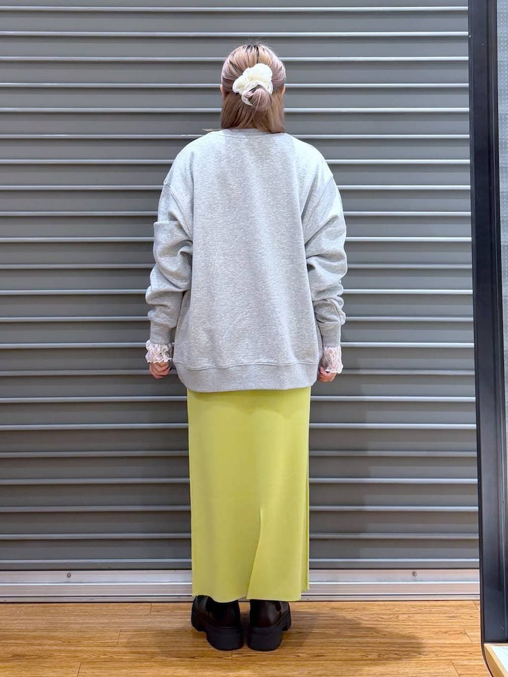 グリーン系のスカート、ブラック系のブーツ、グレー系のスウェットを着用したレディースの冬コーディネートの2枚目の写真