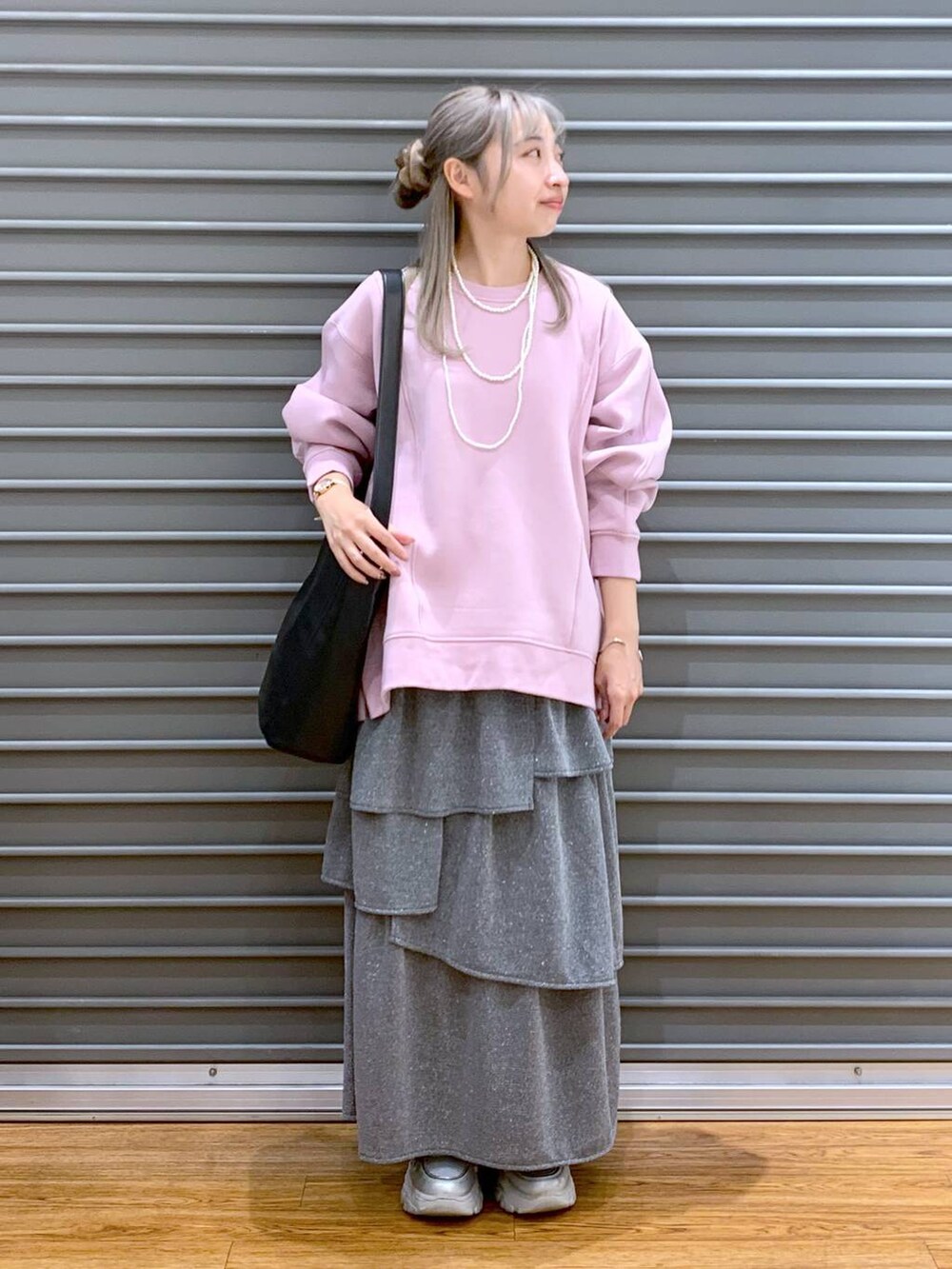 ブラック系のショルダーバッグ、ピンク系のスウェット、シルバー系のスニーカーを着用したレディースの秋コーディネートの5枚目の写真