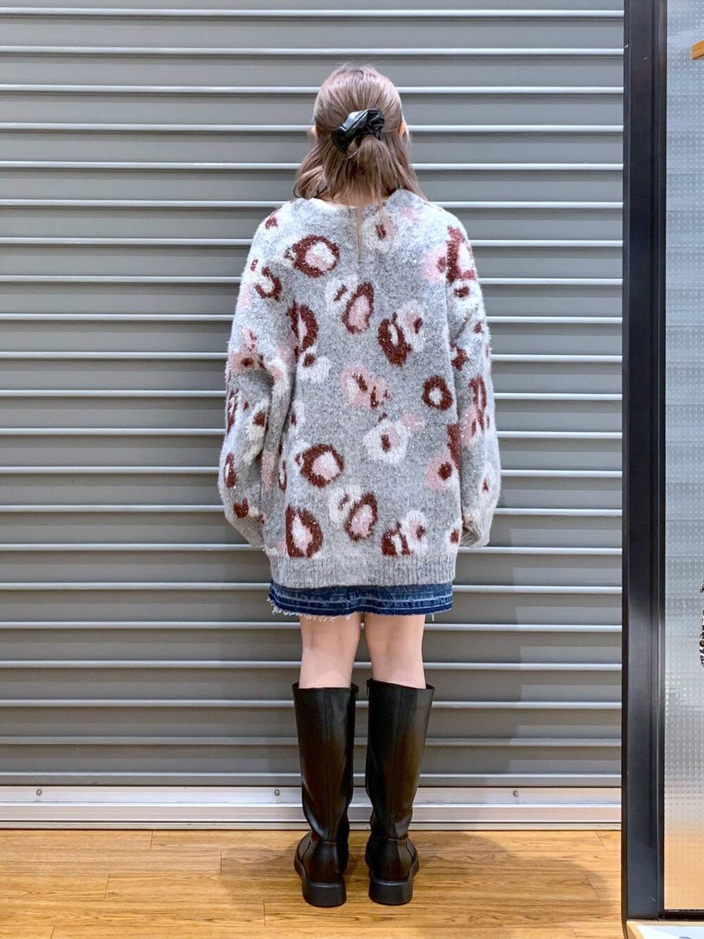 ブルー系のデニムスカート、ブラック系のショルダーバッグ、ブラック系のブーツを着用したレディースの冬コーディネートの2枚目の写真