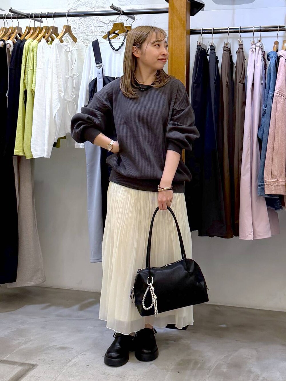 ブラック系のサンダル、ブラック系のボストンバッグ、ホワイト系のスカートを着用したレディースの春コーディネートの4枚目の写真