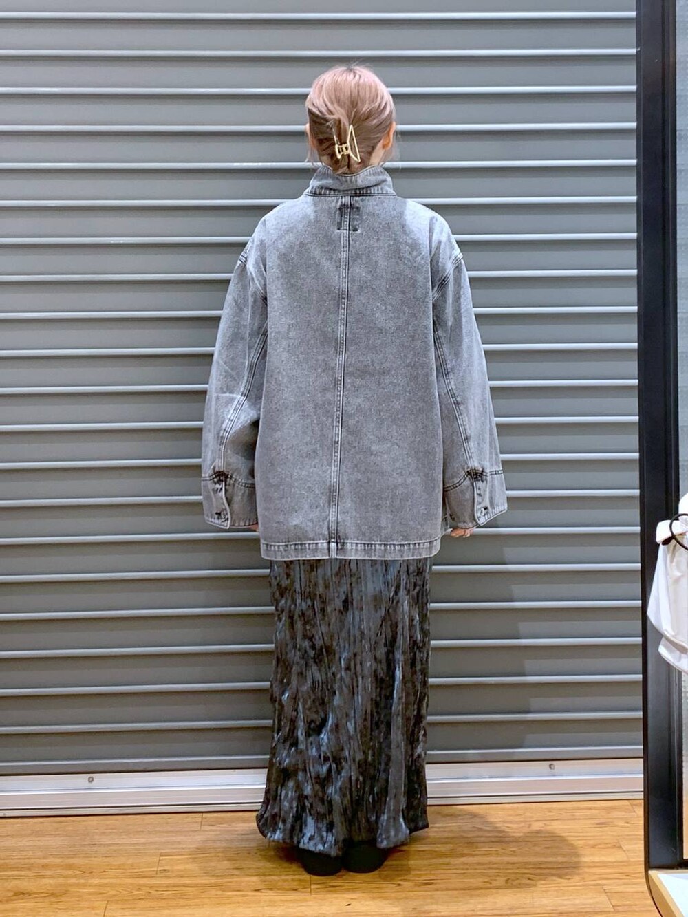 ブラック系のブーツ、グレー系のデニムジャケット、ブラック系のボストンバッグを着用したレディースの秋コーディネートの2枚目の写真