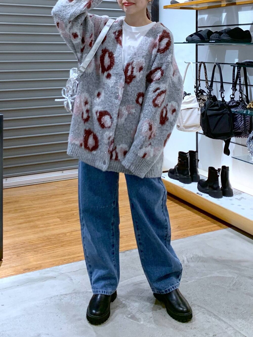 ブラック系のブーツ、ブルー系のデニムパンツ、グレー系のショルダーバッグを着用したレディースの冬コーディネートの3枚目の写真