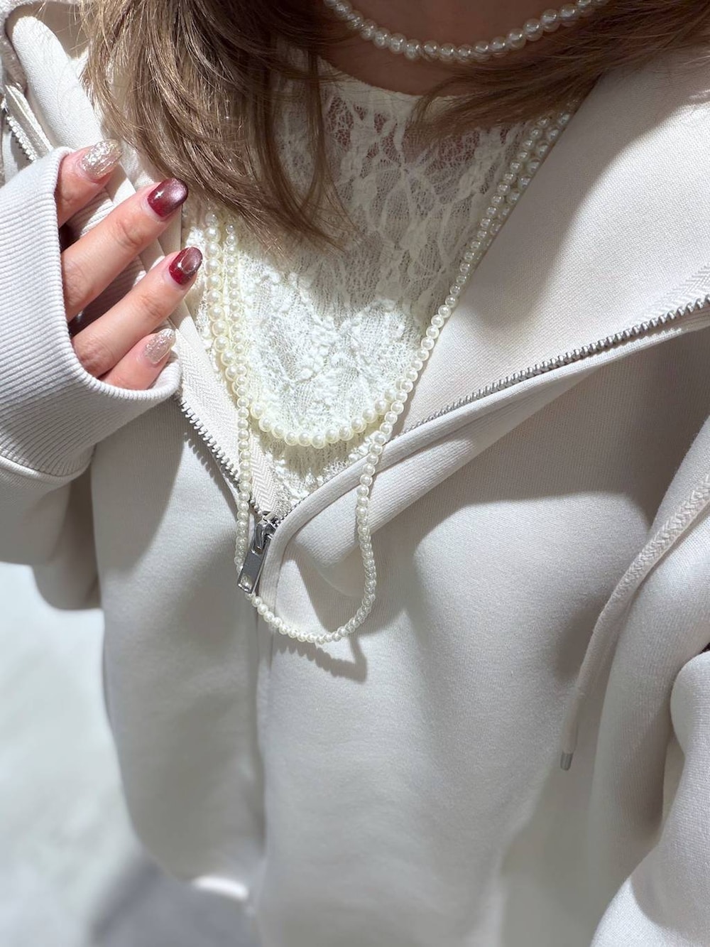 ホワイト系のパーカー、ブルー系のデニムパンツ、ホワイト系のTシャツ/カットソーを着用したレディースの春コーディネートの5枚目の写真