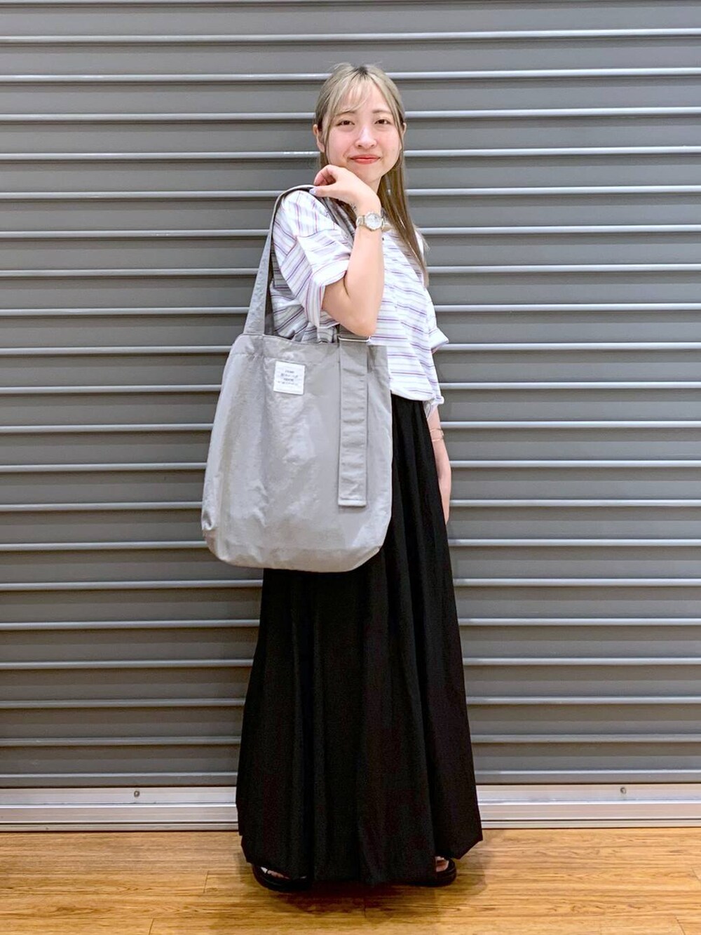 ホワイト系のサンダル、グレー系のトートバッグ、ブラック系のスカートを着用したレディースの夏コーディネートの4枚目の写真