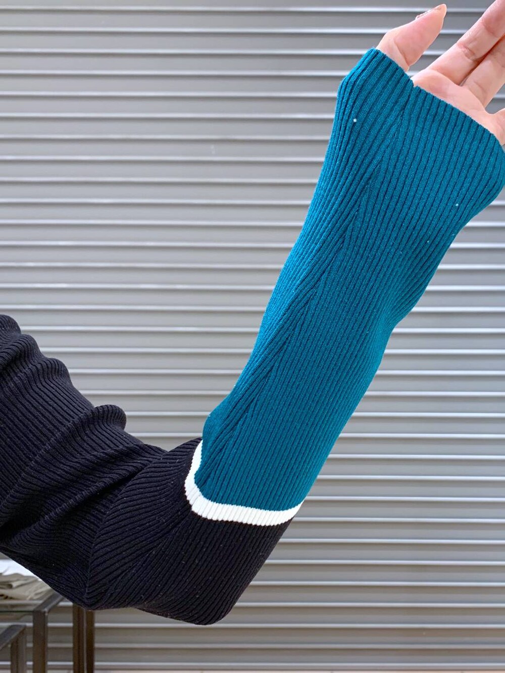 グレー系のブルゾン、ブラック系のニット/セーター、グレー系のスカートを着用したレディースの秋コーディネートの6枚目の写真