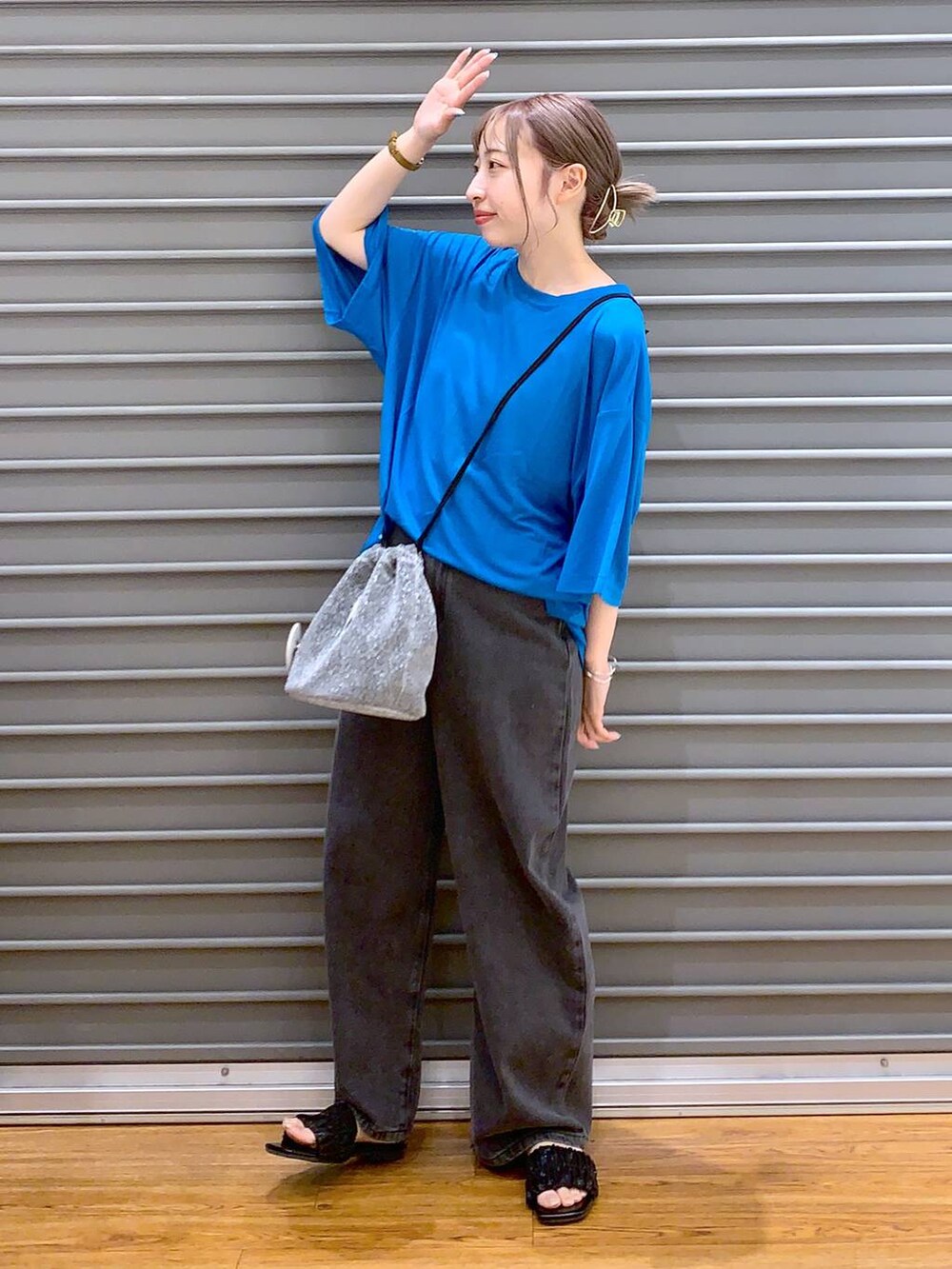 ブルー系のTシャツ/カットソー、グレー系のショルダーバッグ、ブラック系のデニムパンツを着用したレディースの夏コーディネートの3枚目の写真