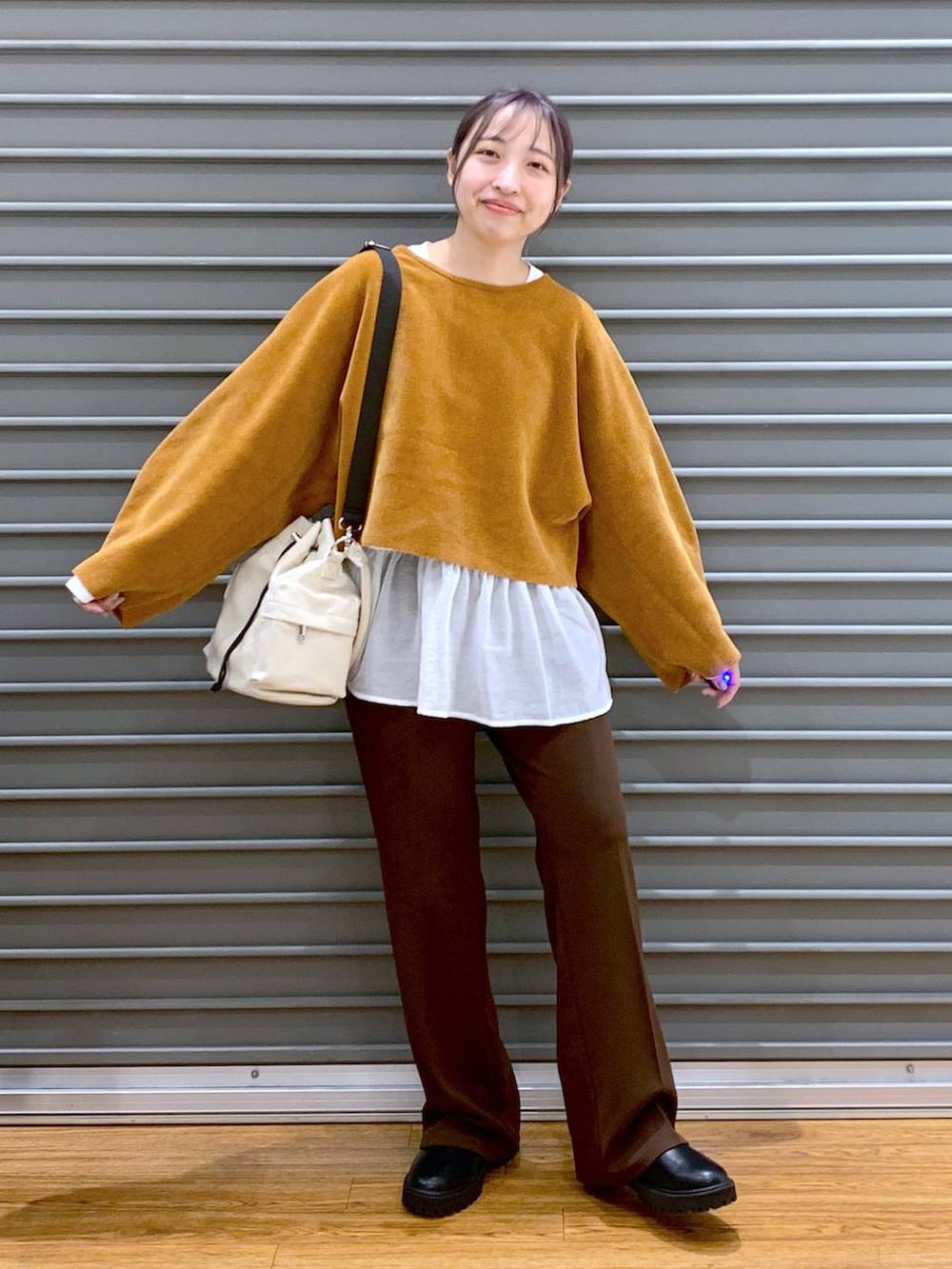 ブラック系のブーツ、ホワイト系のTシャツ/カットソー、ホワイト系のショルダーバッグを着用したレディースの冬コーディネートの4枚目の写真