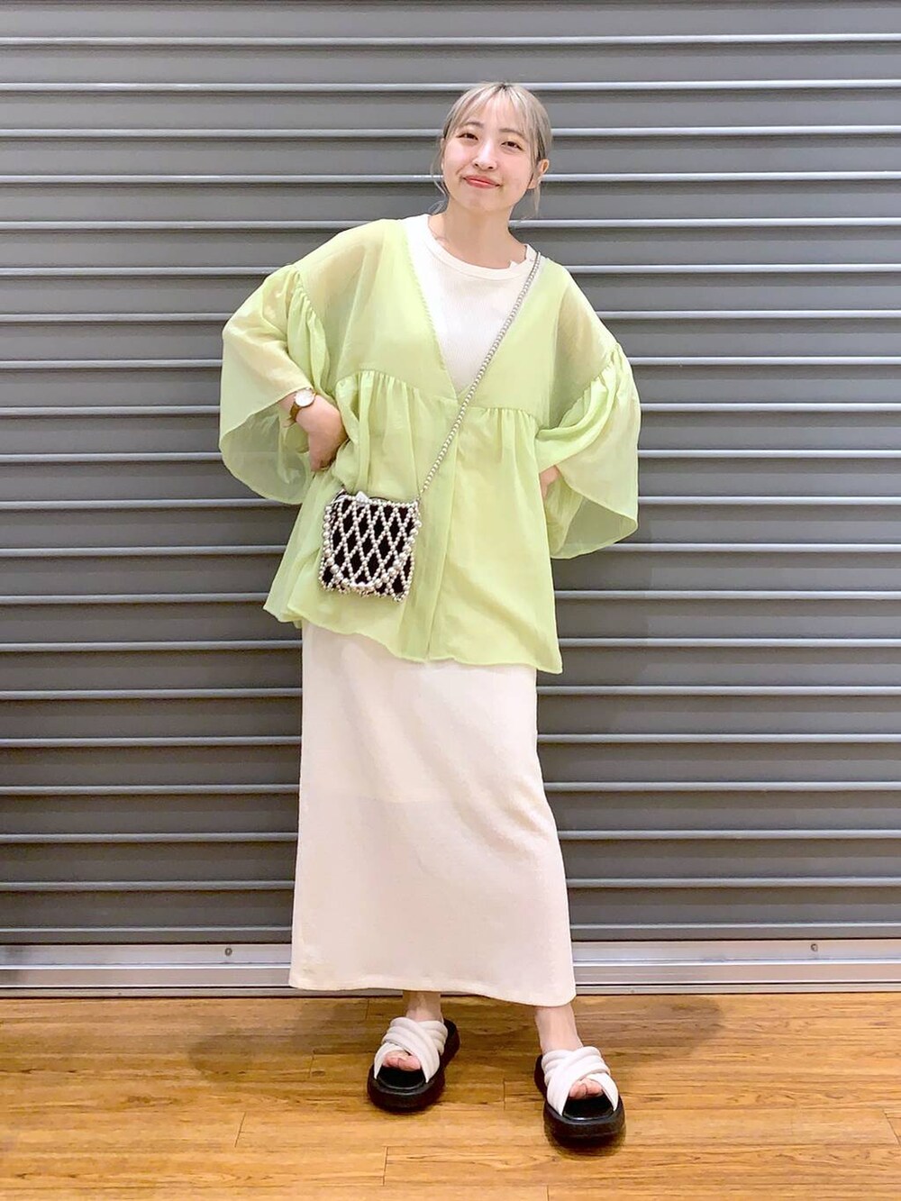 ホワイト系のタンクトップ、イエロー系のシャツ/ブラウス、ホワイト系のスカートを着用したレディースの夏コーディネートの3枚目の写真