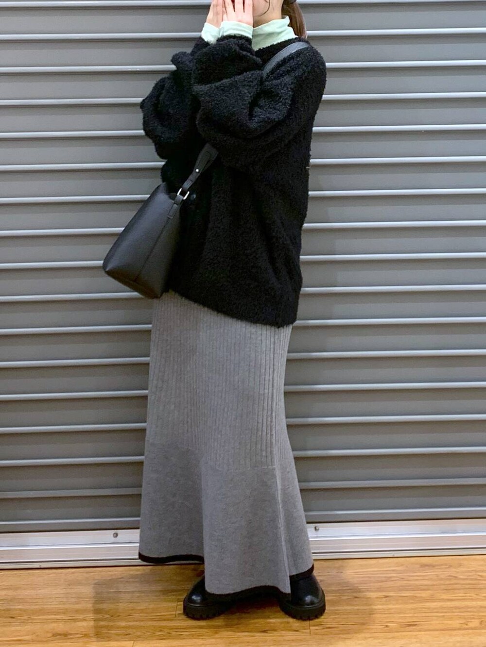 ブラック系のブーツ、ブラック系のワンピース、グリーン系のTシャツ/カットソーを着用したレディースの冬コーディネートの5枚目の写真