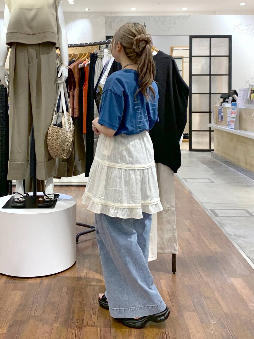 ブルー系のデニムパンツ、ブラック系のサンダル、ブラック系のショルダーバッグを着用したレディースの夏コーディネートの4枚目の写真