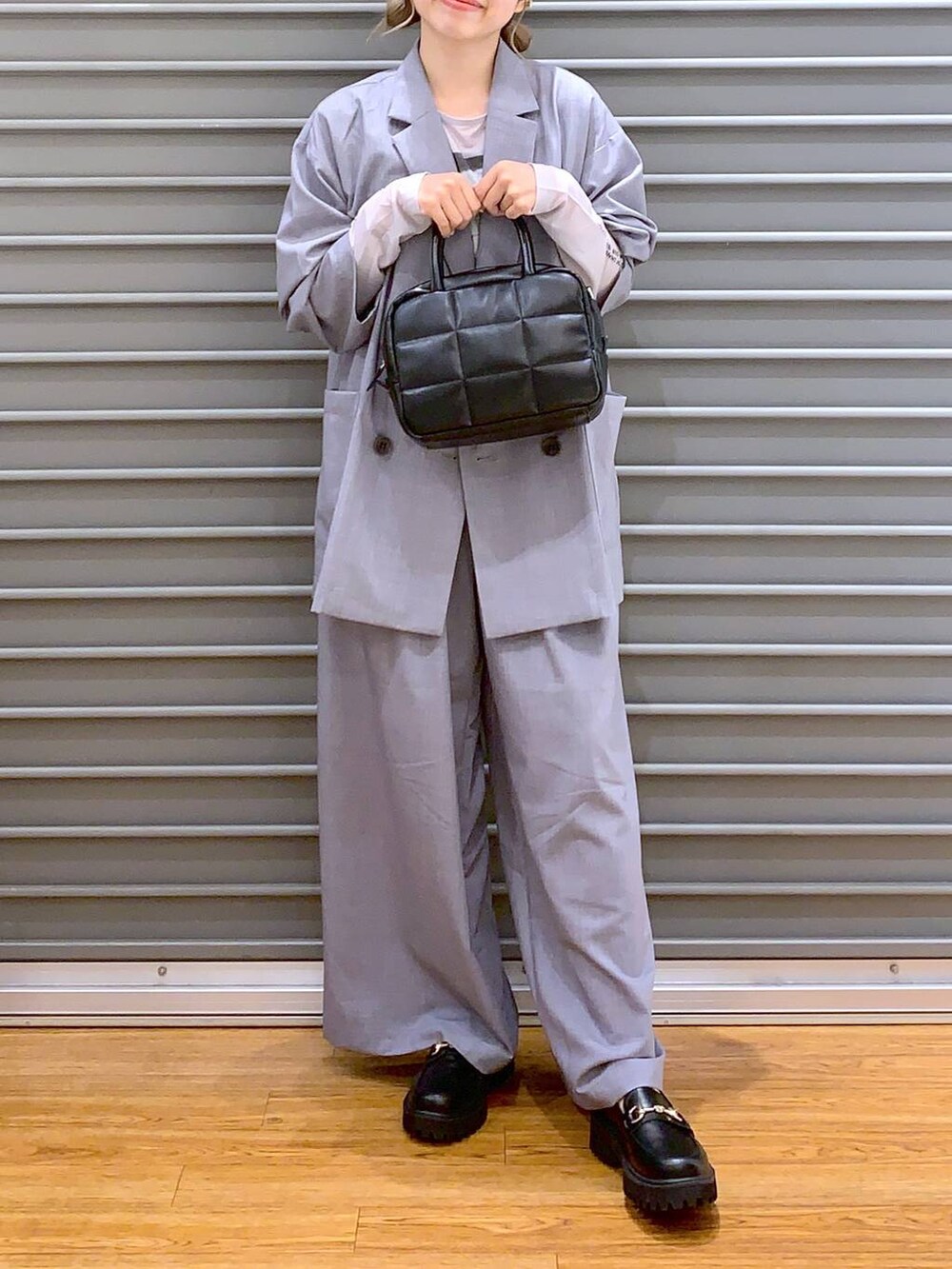 グレー系のスラックス、ブラック系のローファー、グレー系のテーラードジャケットを着用したレディースの夏コーディネートの5枚目の写真