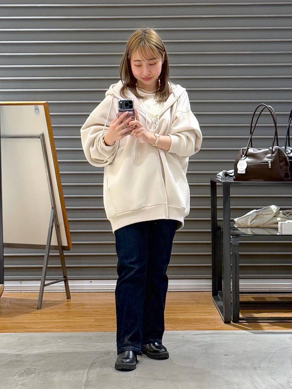 ホワイト系のパーカー、ブルー系のデニムパンツ、ホワイト系のTシャツ/カットソーを着用したレディースの春コーディネートの4枚目の写真