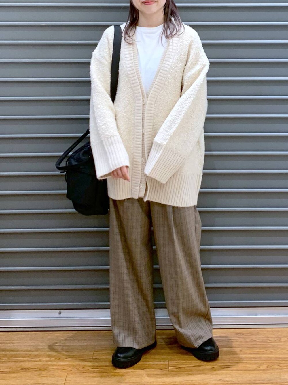 ブラック系のショルダーバッグ、ブラック系のブーツ、ホワイト系のカーディガン/ボレロを着用したレディースの秋コーディネートの6枚目の写真