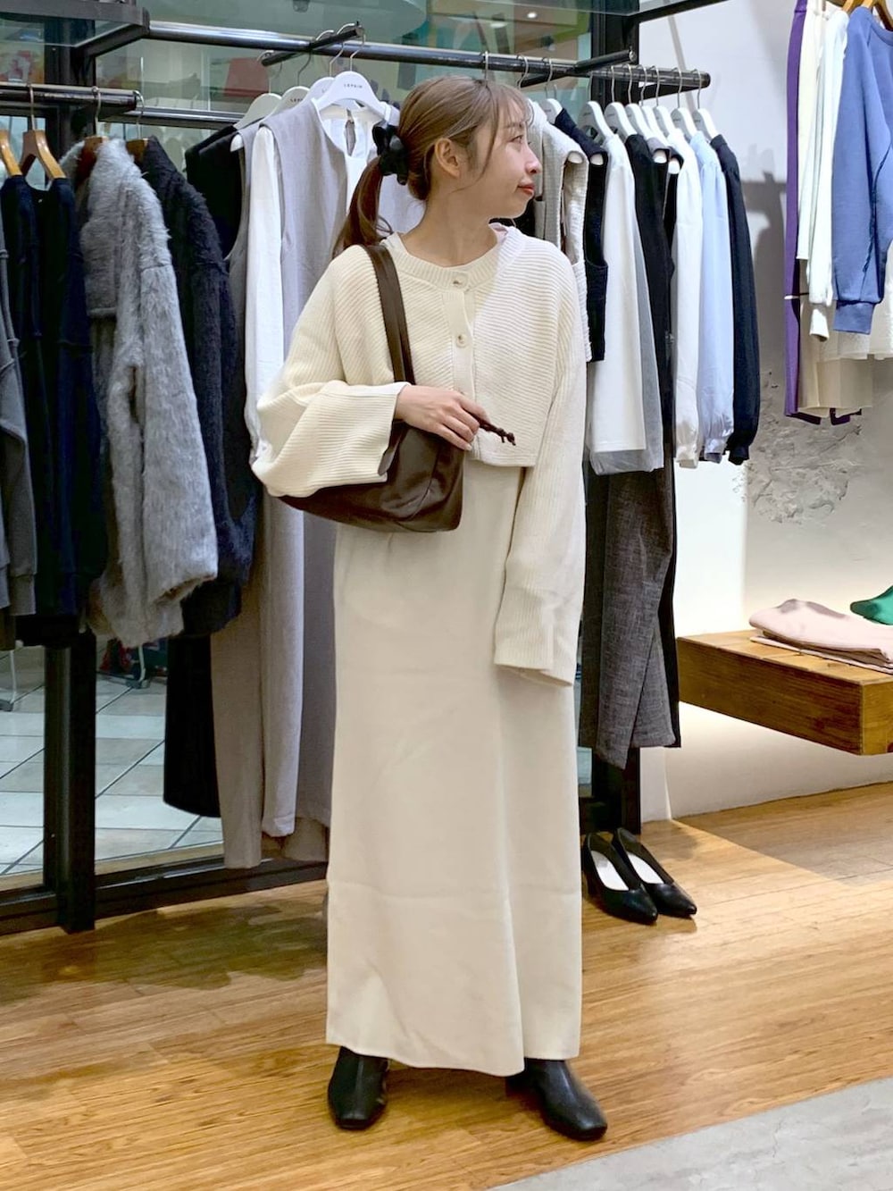 ブラック系のブーツ、ホワイト系のワンピース、ブラウン系のショルダーバッグを着用したレディースの冬コーディネートの2枚目の写真