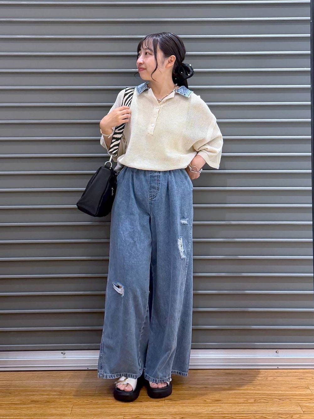 ブルー系のデニムパンツ、ホワイト系のサンダル、ブラック系のショルダーバッグを着用したレディースの夏コーディネートの6枚目の写真
