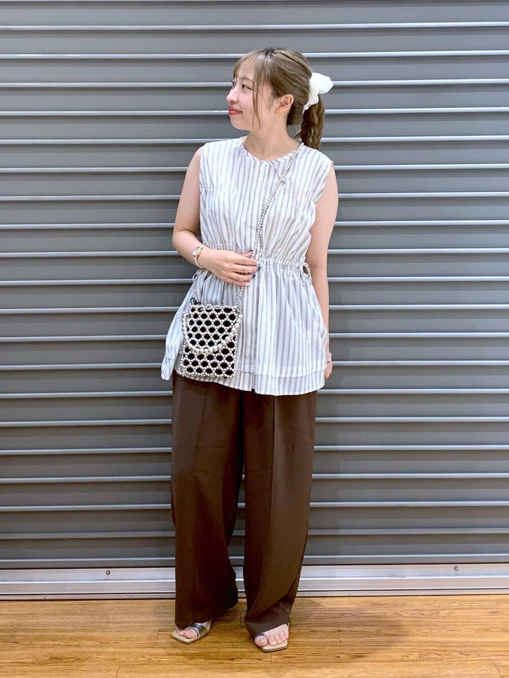 ブラウン系のその他パンツ、シルバー系のショルダーバッグ、ベージュ系のサンダルを着用したレディースの夏コーディネートの4枚目の写真