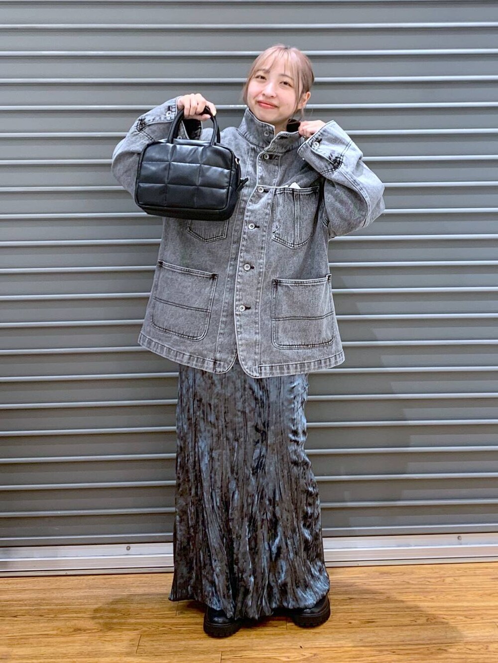 ブラック系のブーツ、グレー系のデニムジャケット、ブラック系のボストンバッグを着用したレディースの秋コーディネートの5枚目の写真