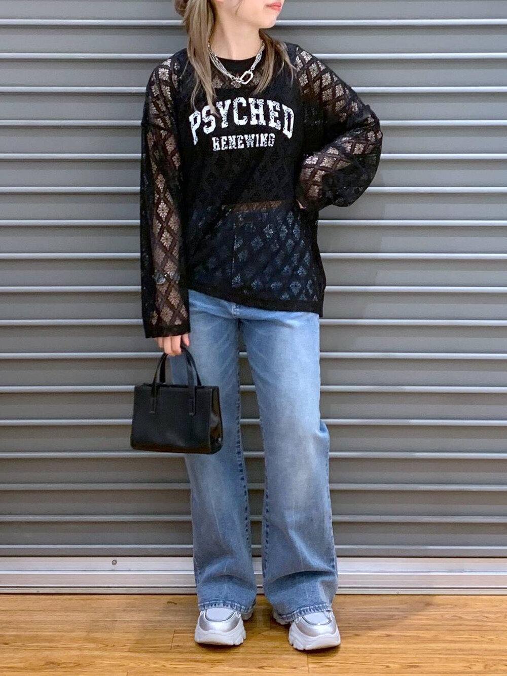 ブルー系のデニムパンツ、ブラック系のタンクトップ、シルバー系のスニーカーを着用したレディースの春コーディネートの5枚目の写真