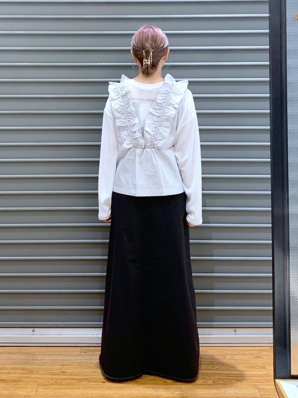 ホワイト系のTシャツ/カットソー、グレー系のスカート、ブラウン系のボストンバッグを着用したレディースの秋コーディネートの2枚目の写真