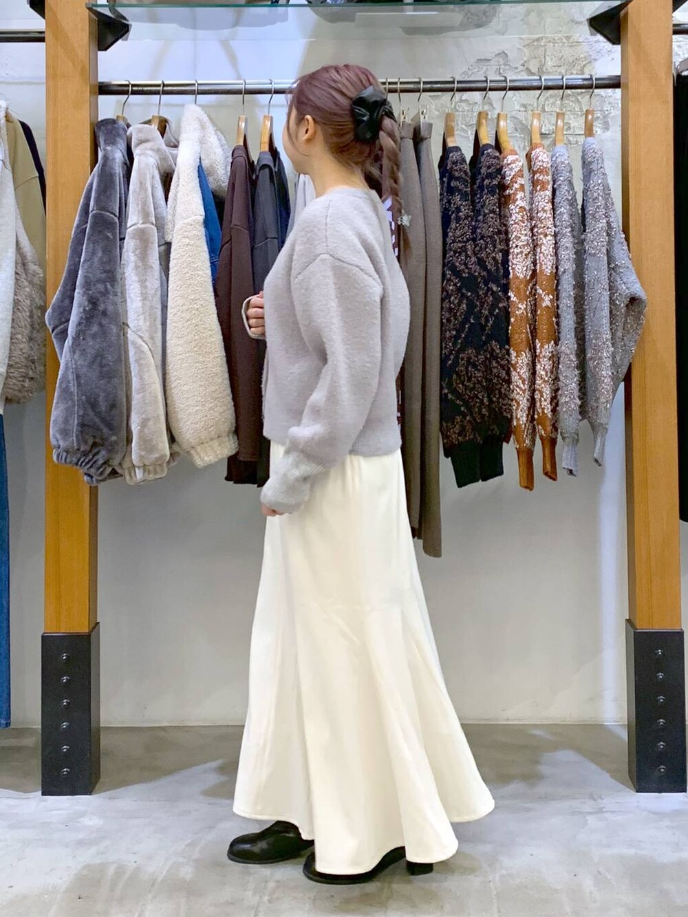 ブラック系のボストンバッグ、ブラック系のブーツ、ホワイト系のブルゾンを着用したレディースの冬コーディネートの5枚目の写真