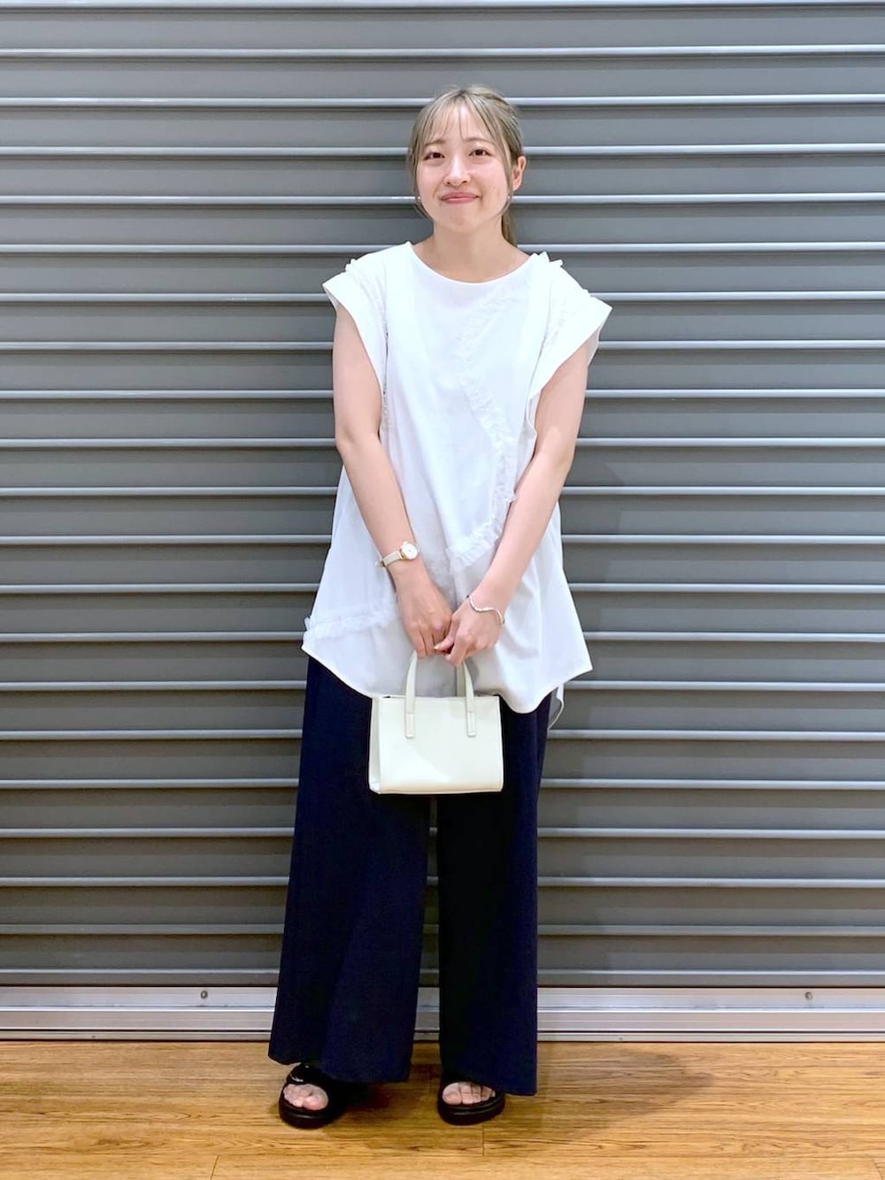 ブラック系のサンダル、ブルー系のその他パンツ、ホワイト系のショルダーバッグを着用したレディースの夏コーディネートの6枚目の写真