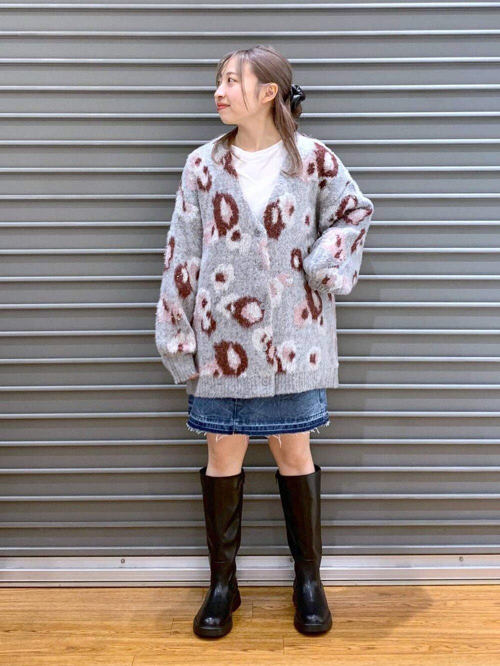 ブルー系のデニムスカート、ブラック系のショルダーバッグ、ブラック系のブーツを着用したレディースの冬コーディネートの4枚目の写真