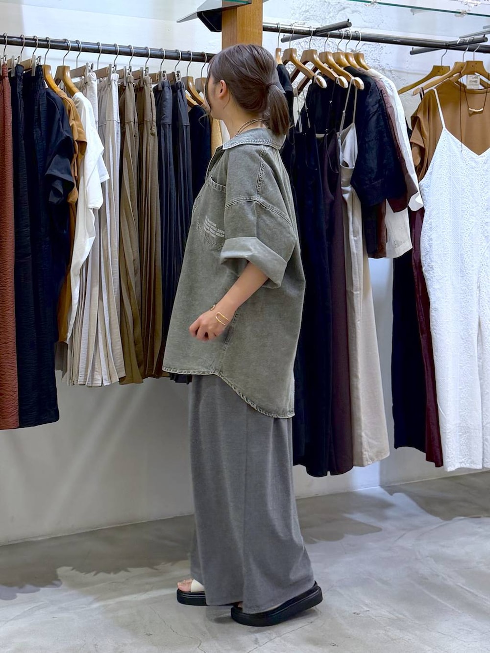 グレー系のその他パンツ、ホワイト系のサンダル、グリーン系のシャツ/ブラウスを着用したレディースの春コーディネートの3枚目の写真