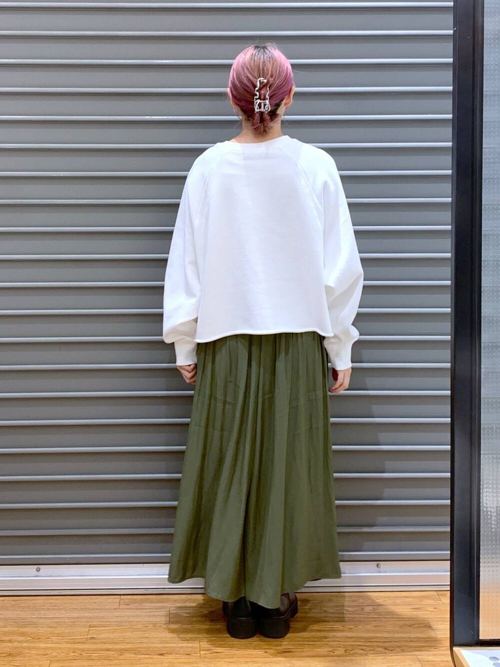 ホワイト系のショルダーバッグ、ブラック系のブーツ、ホワイト系のTシャツ/カットソーを着用したレディースの秋コーディネートの2枚目の写真