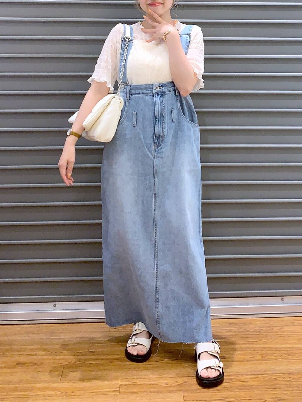 ホワイト系のショルダーバッグ、ホワイト系のキャミソール、ブルー系のジャンパースカートを着用したレディースの春コーディネートの6枚目の写真