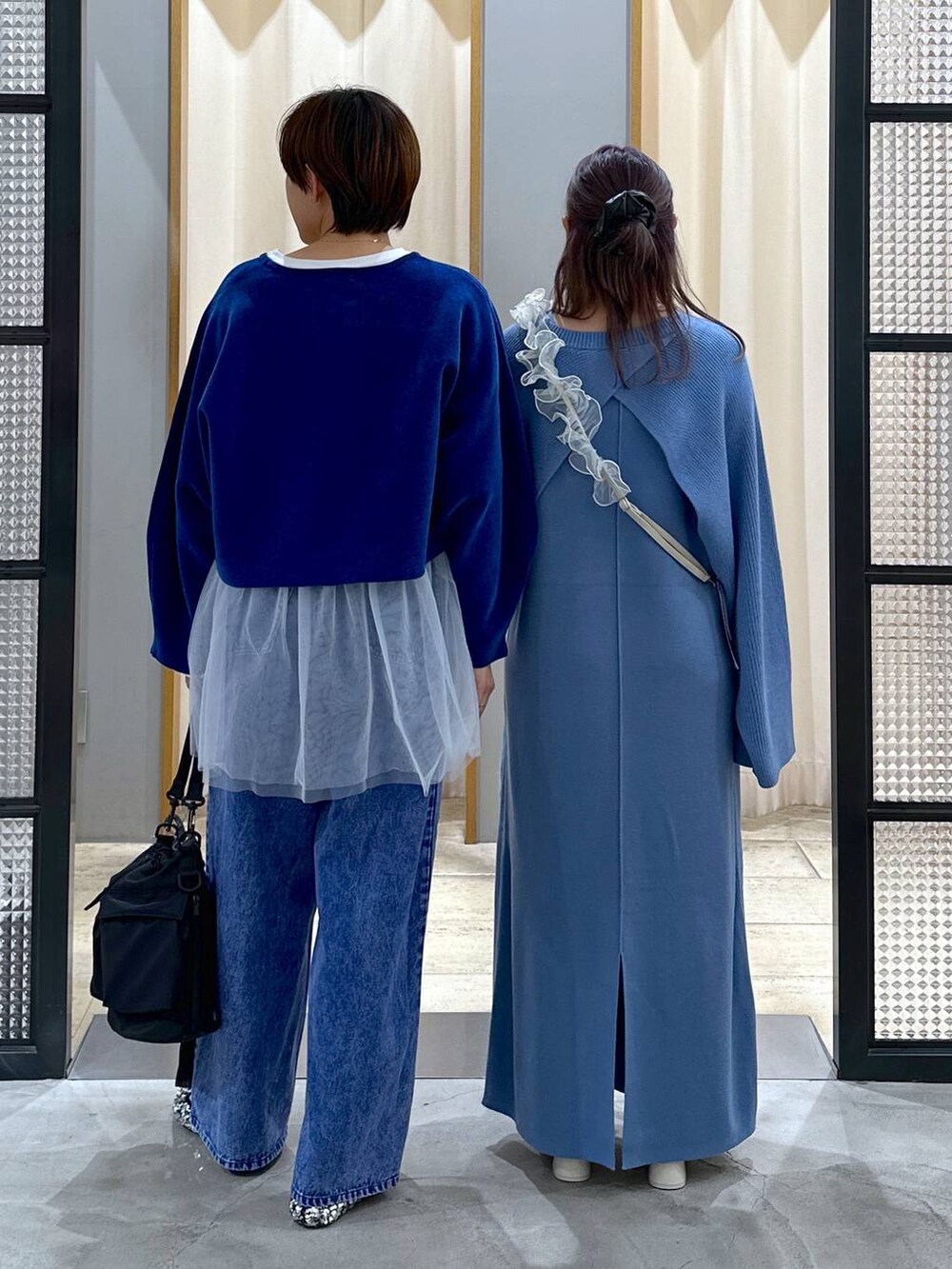 ブラック系のショルダーバッグ、シルバー系のパンプス、ホワイト系のブーツを着用したレディースの冬コーディネートの2枚目の写真