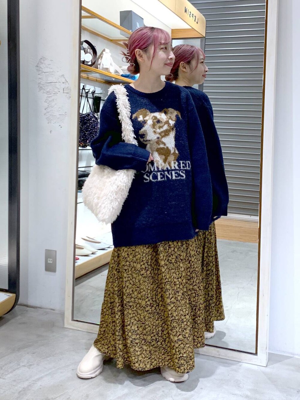 ホワイト系のショルダーバッグ、ホワイト系のブーツ、ブルー系のニット/セーターを着用したレディースの秋コーディネートの5枚目の写真