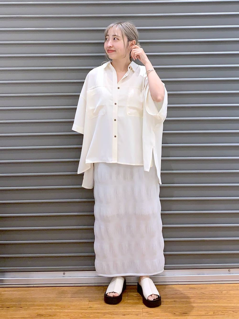 ブラック系のショルダーバッグ、ホワイト系のサンダル、ホワイト系のシャツ/ブラウスを着用したレディースの夏コーディネートの3枚目の写真